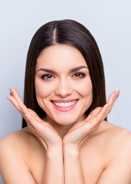 Smiling woman framing her face with her hands