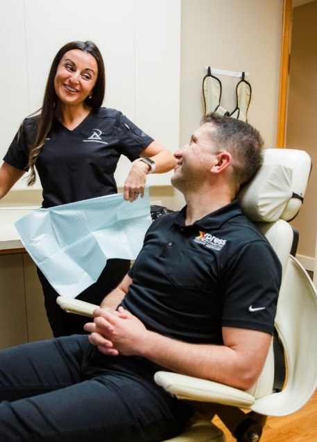 Woman in dental chair listening to her dentist talk
