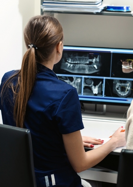 Dentist looking at computer screen showing digital dental x rays in Tampa