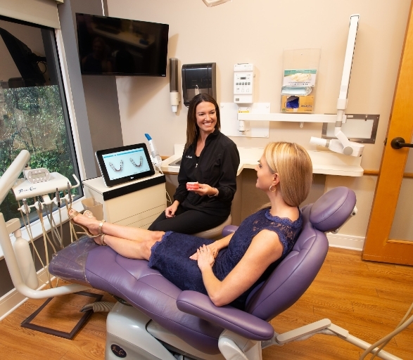 Smiling dentist showing dentures to a patient
