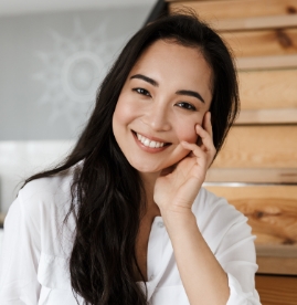 Smiling woman resting her cheek in her hand