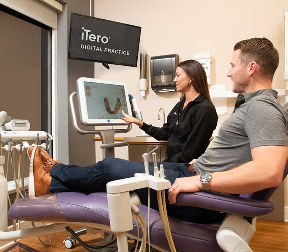 Dentist showing a patient a screen with digital impressions of their teeth