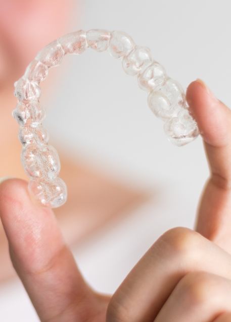 Hand holding an Invisalign tray