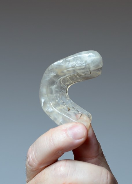 Hand holding a white nightguard