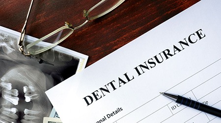 Top of dental insurance form with pen and glasses