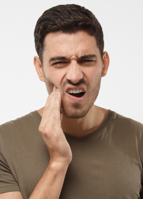 Wincing man holding his jaw