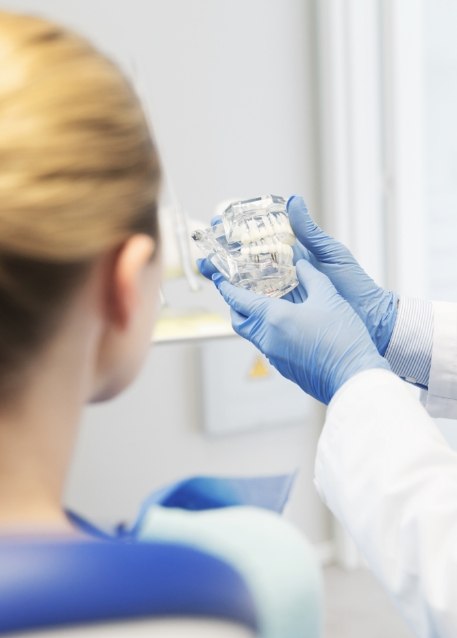 Dentist showing a patient a model of the jaws