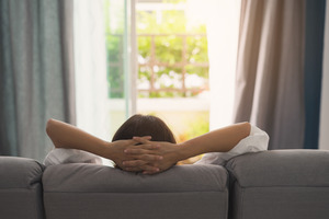 Back view of woman relaxing on couch