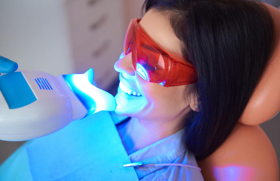 Woman in dental chair getting whitening treatment