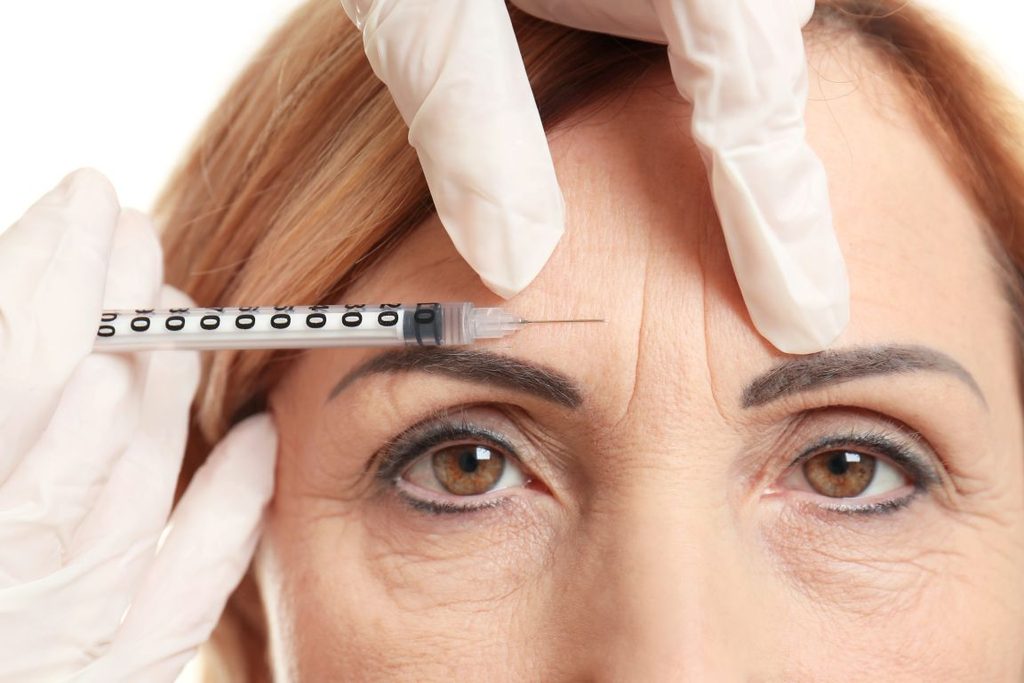 A woman getting a BOTOX injection from her dentist.